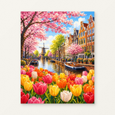 Dutch Canal with Tulips and Blossoms Paint by Numbers Kit — original artwork displayed as a canvas on a warm off-white wall.